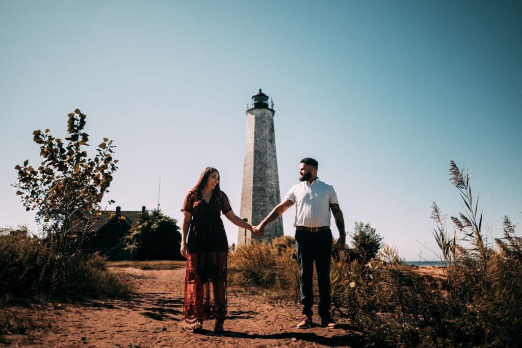 A couple holds hands at Lighthouse Point Park, one of the park wedding venues in Connecticut.