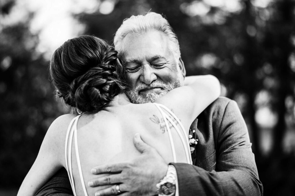 A bride enjoys a first look with her father before her Harkness Park wedding.