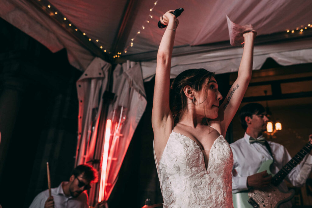 A bride with a microphone performs vocals during the reception of her Harkness Park wedding.
