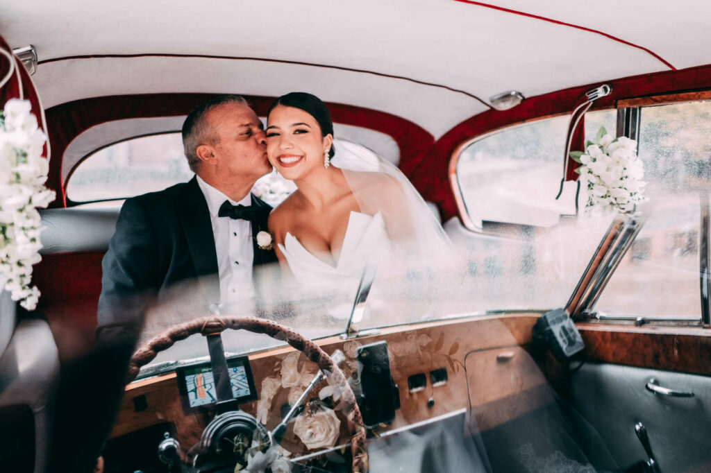 The bride and her father sit in a vintage Rolls Royce car on her Providence Biltmore wedding day.