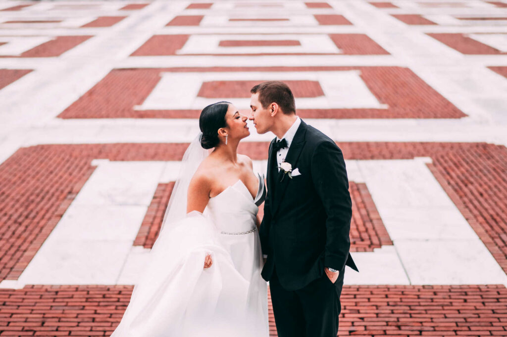 A photo of a bride and groom in the front walkway of the Rhode Island State House before their wedding at Providence Biltmore.